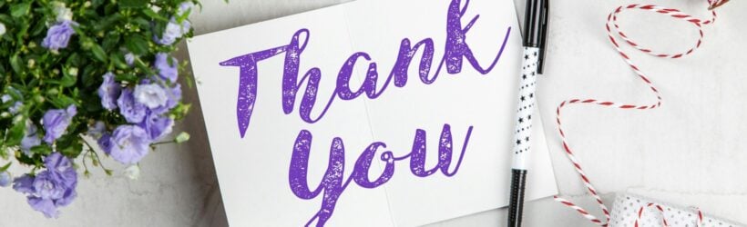 A Thank You card with flowers and a pen, illustrating a donation thank-you letter