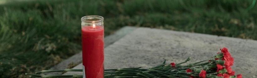 Memorial flowers and a candle, illustrating a tribute or honour donation