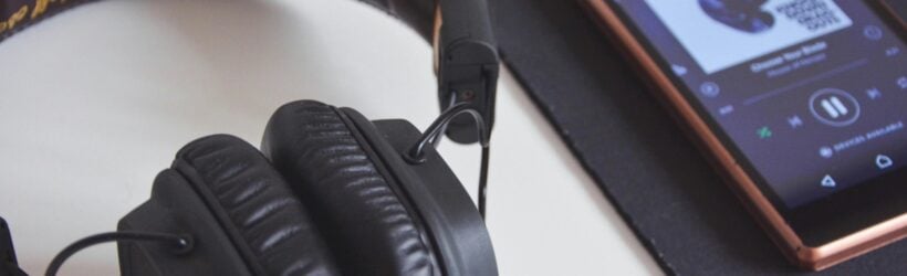 Headphones and a music playlist on a phone, illustrating a donor playlist fundraising idea