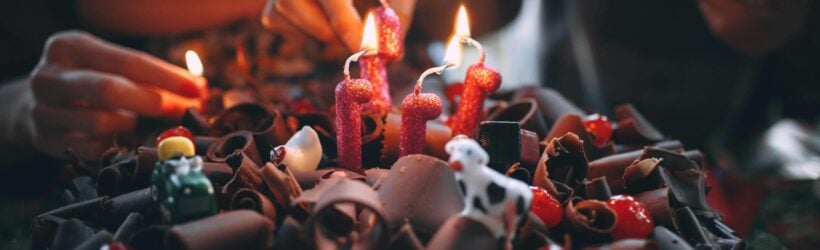 A birthday cake with lit candles, illustrating a birthday fundraiser