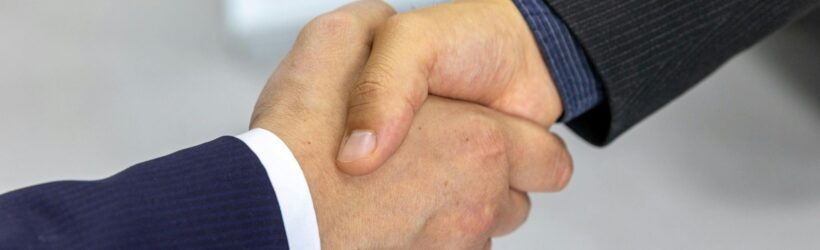 A business handshake, illustrating a corporate matching gift partnership