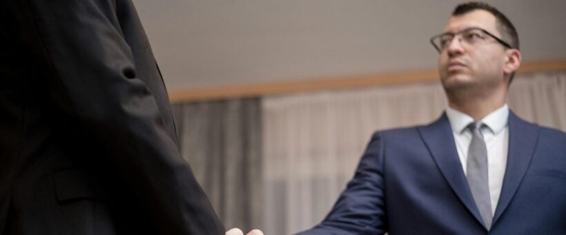 A business and a nonprofit sealing a corporate sponsorship with a handshake