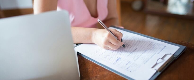 A supporter filling out a donor survey form next to a laptop