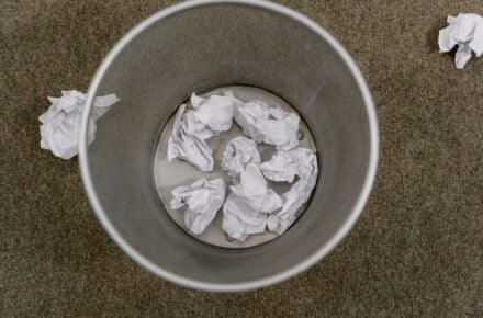 Overhead view of an office waste basket filled with crumpled paper
