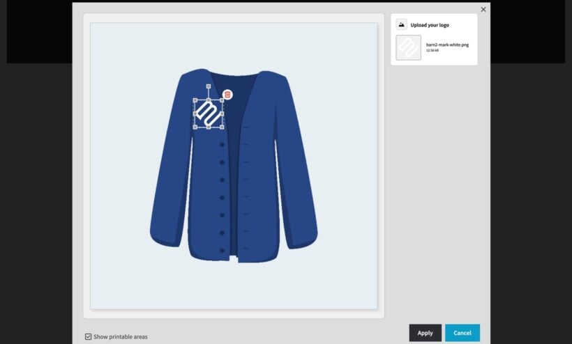 Live Preview editor on a navy knit cardigan, with a small white logo placed inside the embroidery area on the left chest panel and font controls above it